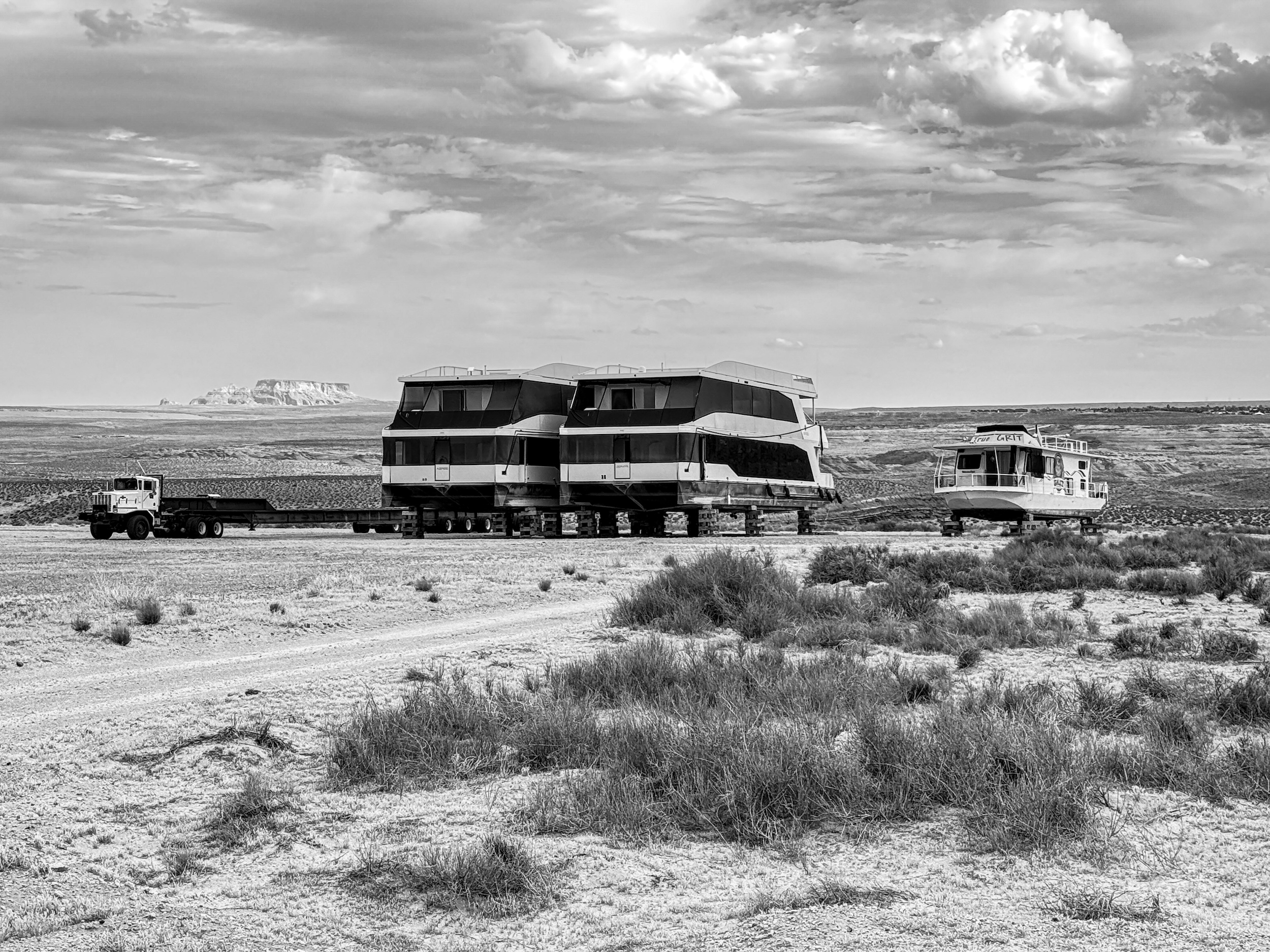 Houseboats on blocks at Lake Powell beneath the True Grit formation